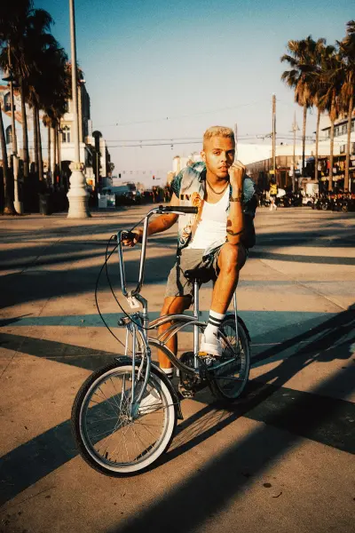 MM News Musiknews Malik Harris Pressefoto Auf Dem Fahrrad Posend