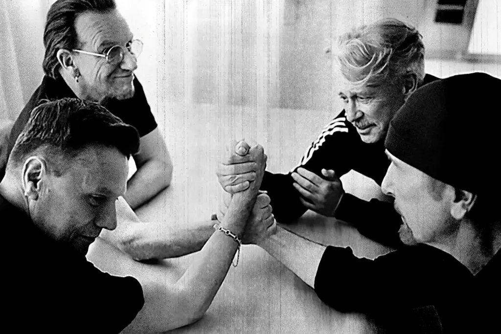 MM News Musiknews U2 -Die vie Musiker von U2 sitzen am Tisch und reichen sich die Hände. New Ep Dof